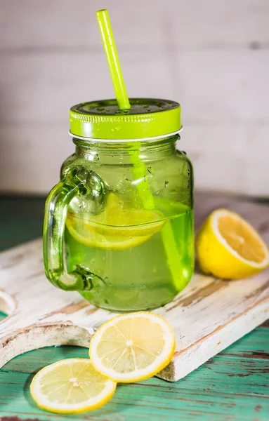 新鲜的柠檬水放在装有柠檬片的玻璃瓶中 — 图库照片