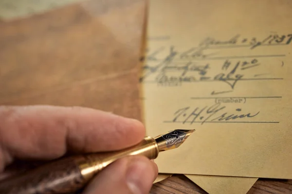 Vintage writing utensils on a wooden table, old watch, papers, letters, envelopes and scissors