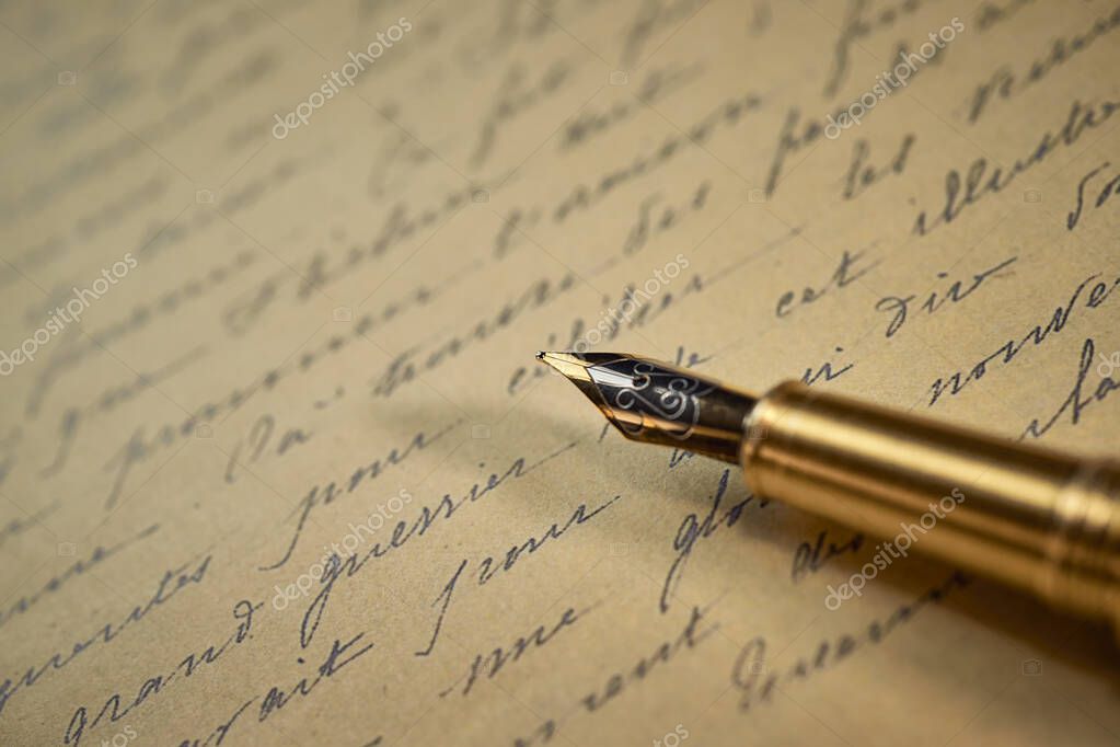 Vintage writing utensils on a wooden table, old watch, papers, letters, envelopes and scissors