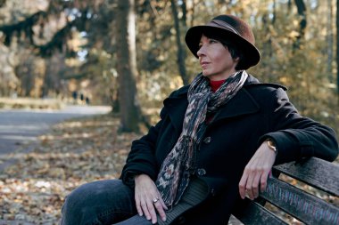 40 'lı yaşların zarif hanımı ekim ayında parkta yürüyor.