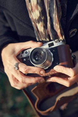 Parkta eski model fotoğraf makinesi kullanan 40 'lı yaşlarda zarif bir bayan.