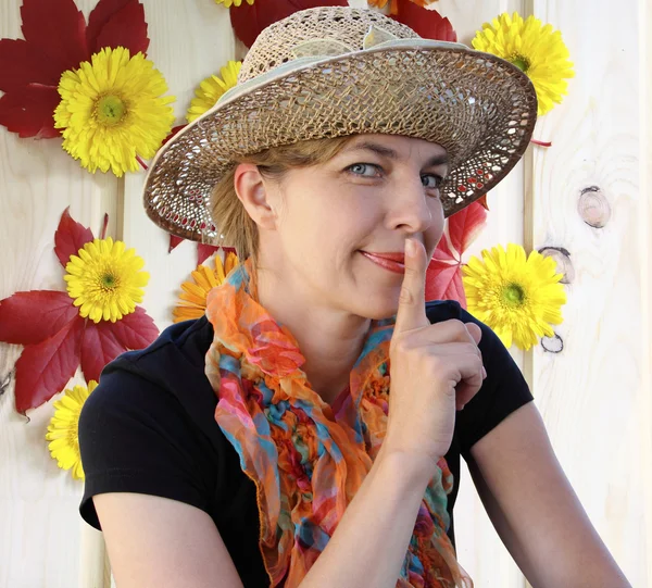 Woman in a hat shows quietly and smiles — Stock Photo, Image