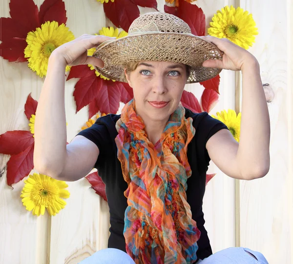 A woman in a hat on a background a wall with colors looks far — Stock Photo, Image