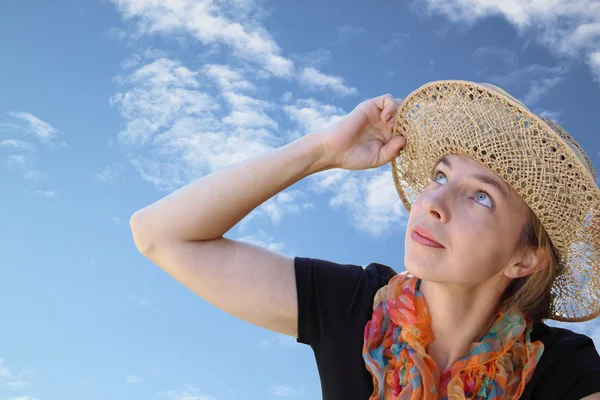 Blue sky adlı ilgiyle şapkalı bir kadın bakar — Stok fotoğraf