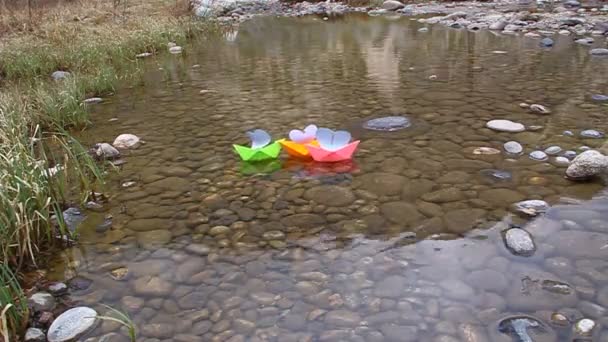 Barcos de papel de colores flotando en un pequeño lago — Vídeos de Stock