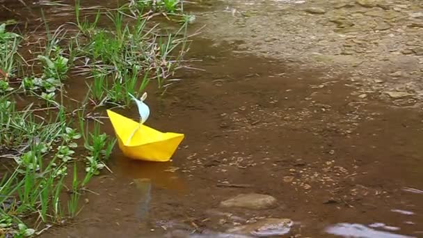 Barco de papel amarillo flotando en el lago — Vídeos de Stock