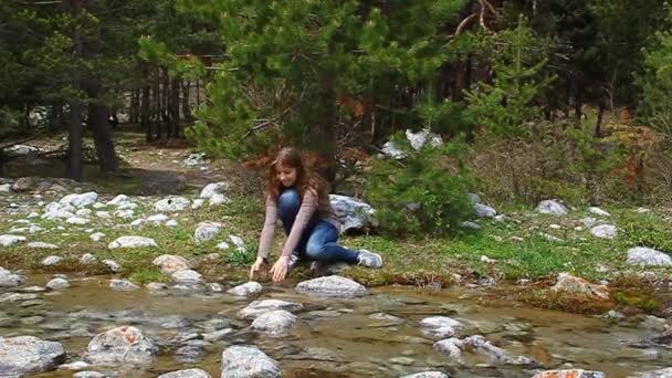 Gelukkig, vrolijk meisje spuiten van water uit de kreek en lacht — Stockvideo
