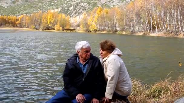 Feliz casal idoso sentado e falando no lago — Vídeo de Stock
