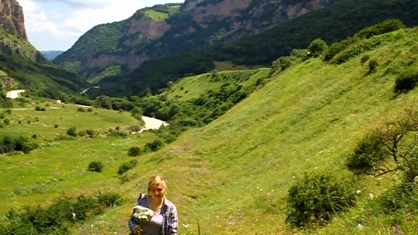 Donna felice sdraiata sulla montagna con un mazzo di margherite — Video Stock