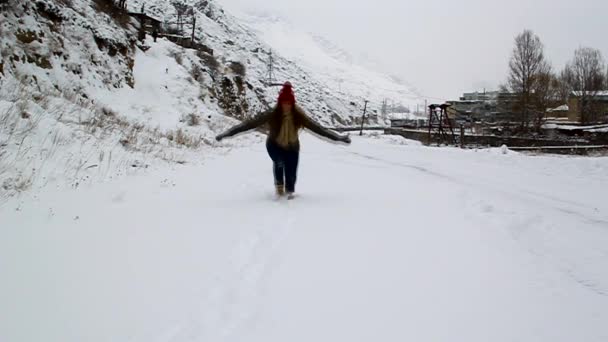 若い女の子の冬の雪および投球歩く — ストック動画