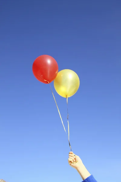 Hava el helyum balonları mavi gökyüzü arka plan üzerinde kırmızı ve altın 