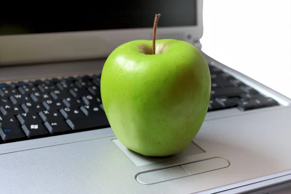 Green apple sitting on laptop — Stock Photo, Image