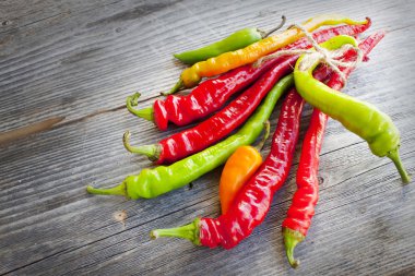 ahşap dokulu arka plan üzerinde renkli hot chilli peppers