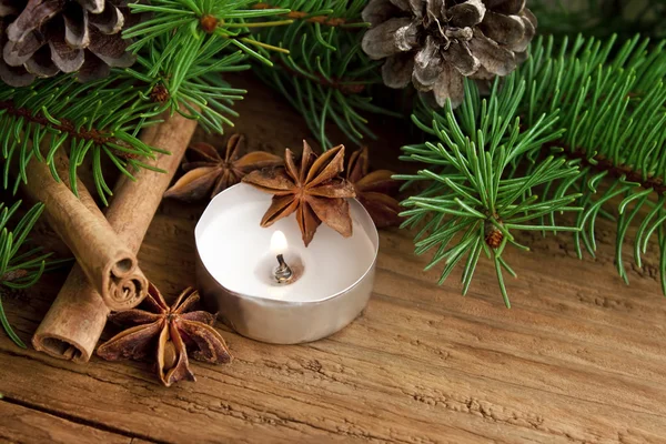 Holiday decoration with candle,fir and cinnamon on wooden backgr — Stock Photo, Image