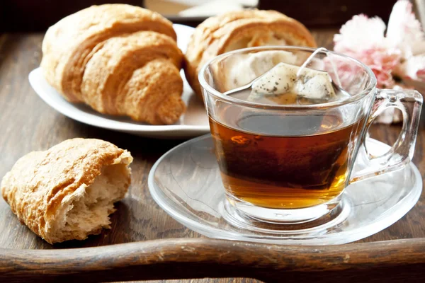 Té en taza transparente con cruasanes —  Fotos de Stock