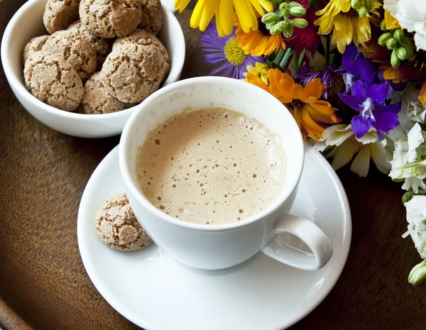 Cappuccino s amaretti sušenky a květiny — Stock fotografie