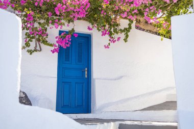 Santorini adasında mavi kapılı beyaz Kiklad mimarisi, Yunanistan geniş panoramik formatında. Seyahat yeri geçmişi, eski geleneksel cadde, sokak macerası