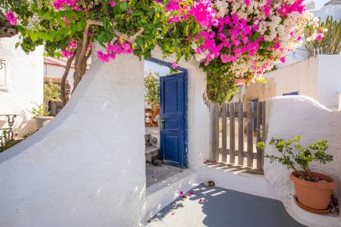 Santorini adasında mavi kapılı beyaz Kiklad mimarisi, Yunanistan geniş panoramik formatında. Seyahat yeri geçmişi, eski geleneksel cadde, sokak macerası