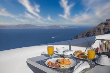 Oteldeki Santorini 'de kahvaltı zamanı. Taze omletle lüks bir ruh hali ve deniz manzaralı meyve suyu. Şatafatlı yaz tatili geçmişi. Mutlu rahatlama titreşimleri, çift sabah yakın çekim masası