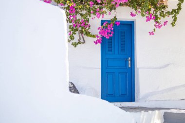 Santorini adasında mavi kapılı beyaz Kiklad mimarisi, Yunanistan geniş panoramik formatında. Seyahat yeri geçmişi, eski geleneksel cadde, sokak macerası