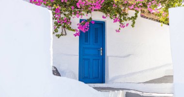 Santorini adasında mavi kapılı beyaz Kiklad mimarisi, Yunanistan geniş panoramik formatında. Seyahat yeri geçmişi, eski geleneksel cadde, sokak macerası