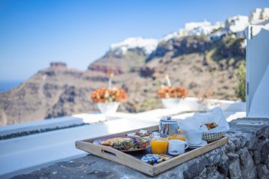 Oteldeki Santorini 'de kahvaltı zamanı. Taze omletle lüks bir ruh hali ve deniz manzaralı meyve suyu. Şatafatlı yaz tatili geçmişi. Mutlu rahatlama titreşimleri, çift sabah yakın çekim masası