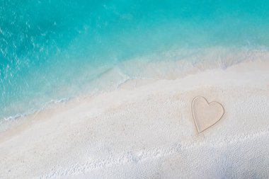 Kalp şeklinde kum olan tropik ada plajı. İdealist romantik aşk ve balayı yaz tatili tatil geçmişi kavramı. Romantizm ve çift sembolü ile inanılmaz bir doğa. Üst hava manzarası, deniz kıyısı.