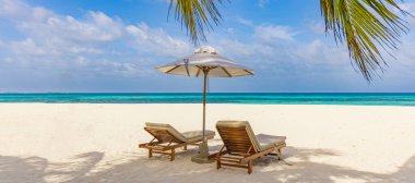 Deniz kenarındaki kumlu sahilde sandalyeler. Yaz tatili ve turizm için tatil konsepti. İlham verici tropikal manzara