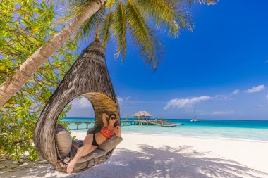 Güzel bir kadın tropik adanın kumsalında dinleniyor.