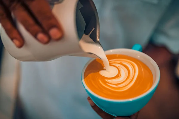 barista pouring coffee in cup