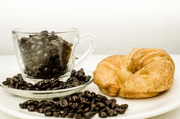 Šálek kávy lusky s croissantem — Stock fotografie
