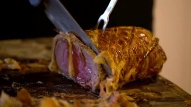 Şef misafirlere servis etmek için Porchetta 'yı kesiyor.