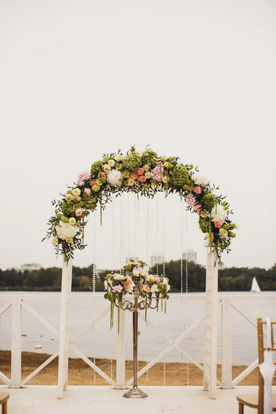 Svatební květinový oblouk na pláži — Stock fotografie