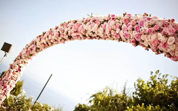 Růžových růží a pivoněk svatební oblouk — Stock fotografie