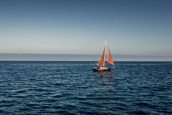 Denizin içinde kırmızı bir yelken ile yat — Stok fotoğraf