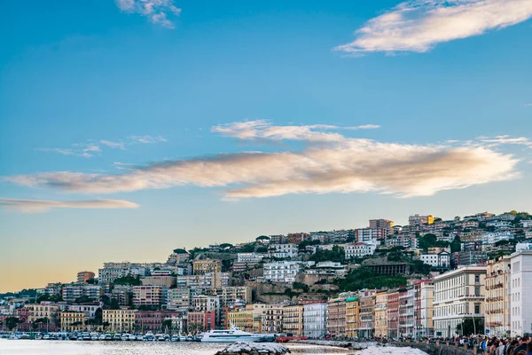 Kasvetli bir bahar akşamında Napoli körfezinde yüzen balıkçı tekneleri. Napoli rıhtımı, arkasında Napoli tepeleri ve binaları var. İtalya — Stok fotoğraf