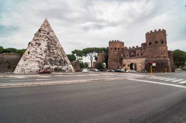 Roma, İtalya - 30 Eylül 2012. Arka planda Cestius Piramide di Caio Cestio veya Piramide Cestia ve Porta San Paolo geçidi yer almaktadır. Piazzale Ostiense Meydanı 'ndan görüntü. Roma, Lazio, İtalya.