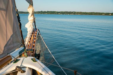 Sails folded and lashed to the bow on the Atalntic Ocean in Maine, USA clipart