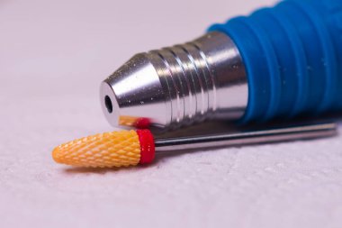 Kırmızı çentik ve manikür makinesinin sapıyla seramik değirmen kesicisi.