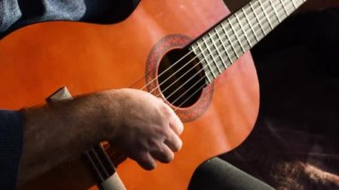 Bir adam klasik gitar çalıyor..