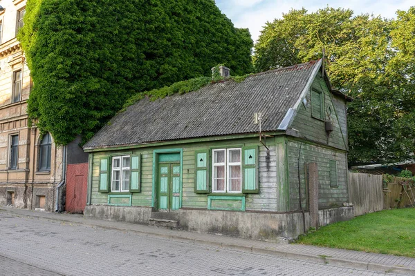 The brick house, which one wall is overgrown with creepers in Ventspils, Latvia.