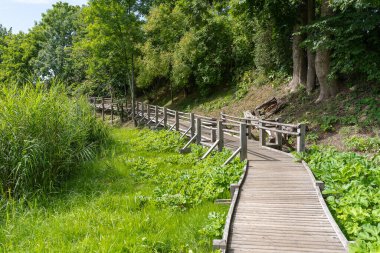 Wooden footpath along a small river. Beautiful natural landscape.