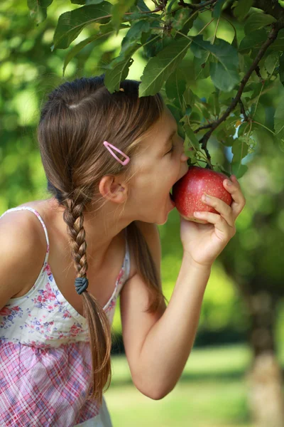 Flicka biter i ett äpple — Stockfoto