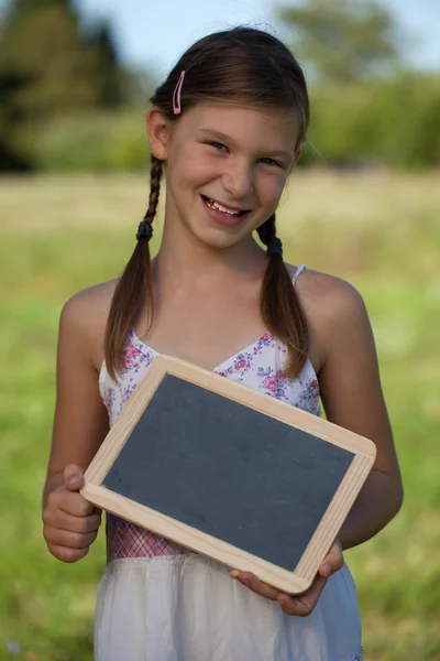Молодая девушка держит маленькую доску — стоковое фото