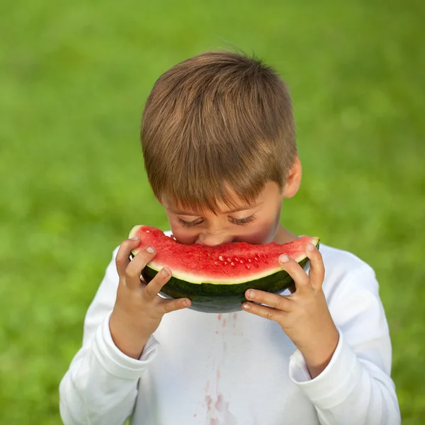 Kleine jongen eten een verse watermeloen — Stockfoto