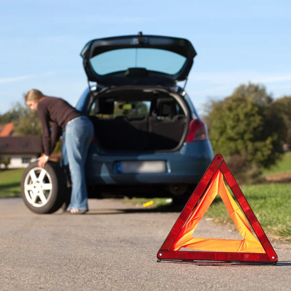 Changing the tire on a broken down car — Stok fotoğraf