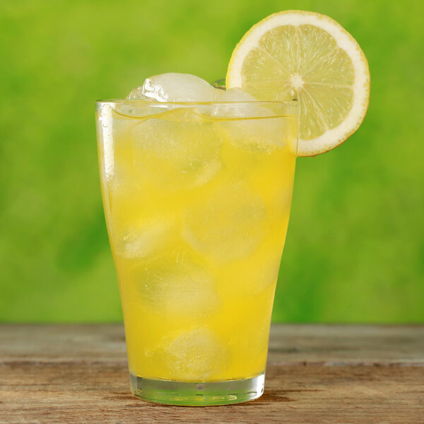 Холодный оранжевый лимонад в стакане
