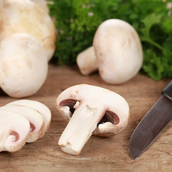 Voedselbereiding: gesneden champignons op een snijplank — Stockfoto