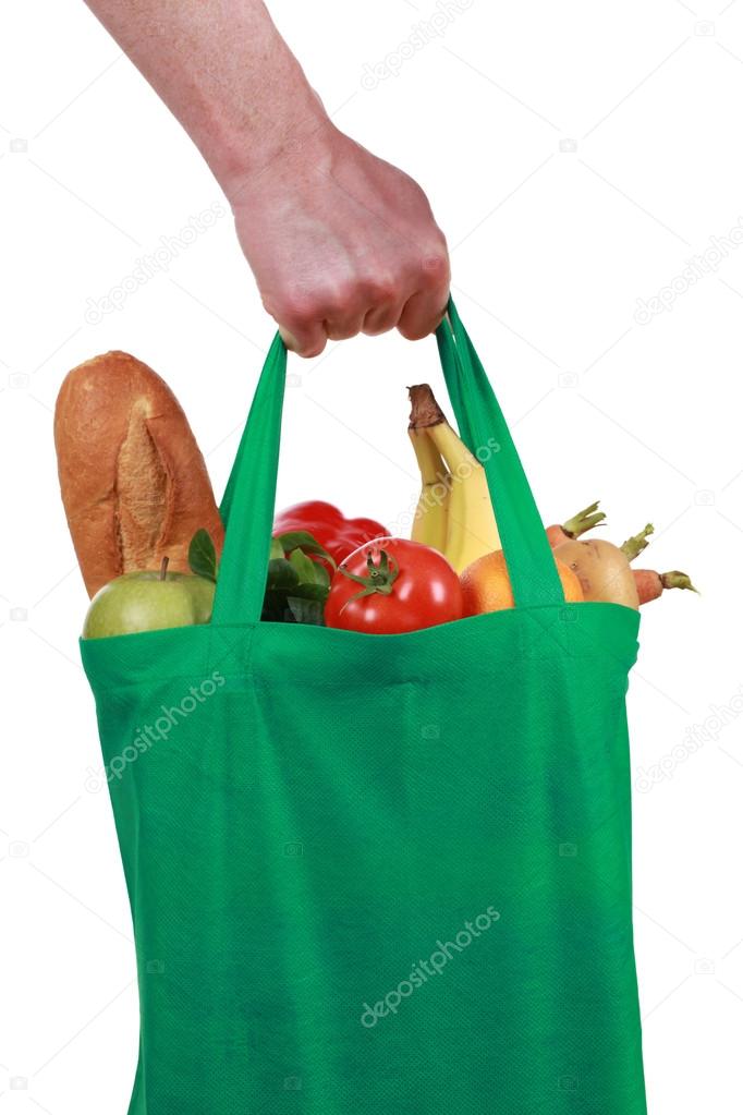 Hand holding a bag with groceries