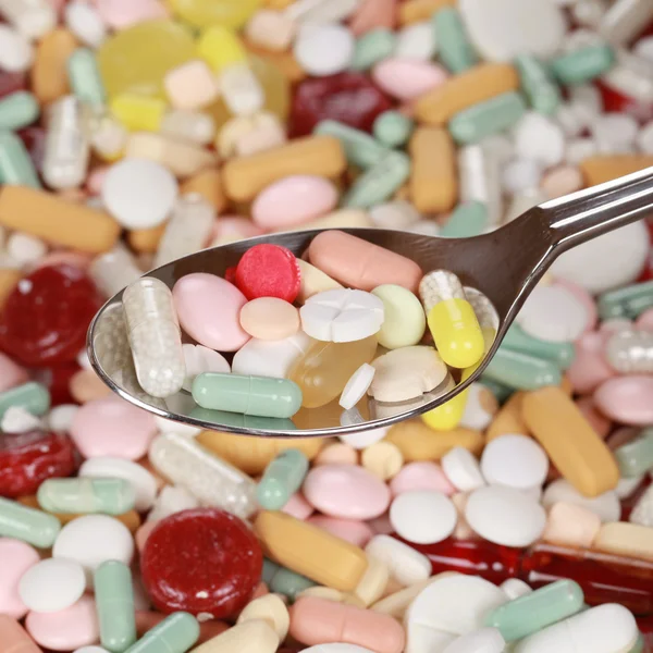 Pills and capsules on a spoon — Stock Photo, Image